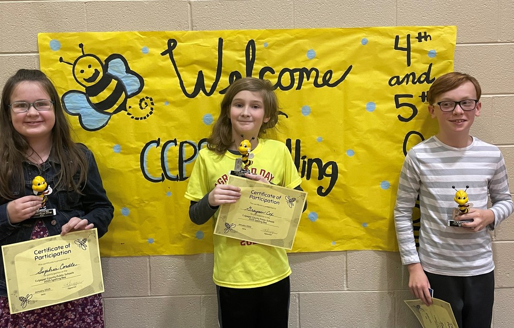spelling bee winners with trophies and certificates