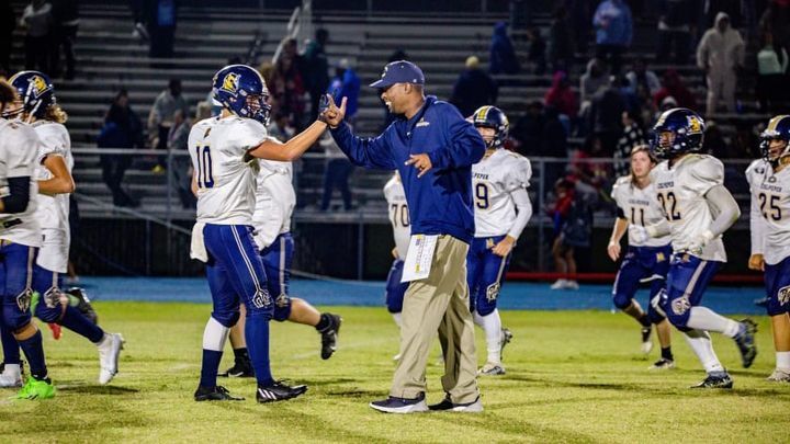 football coach congratulates player on the field