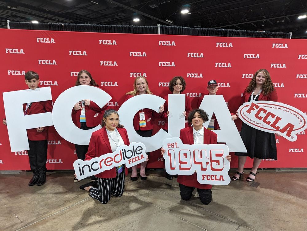 students in front of red background holding huge FCCLA letters