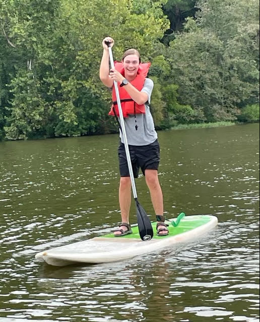 10th grade student paddleboarding on the lake
