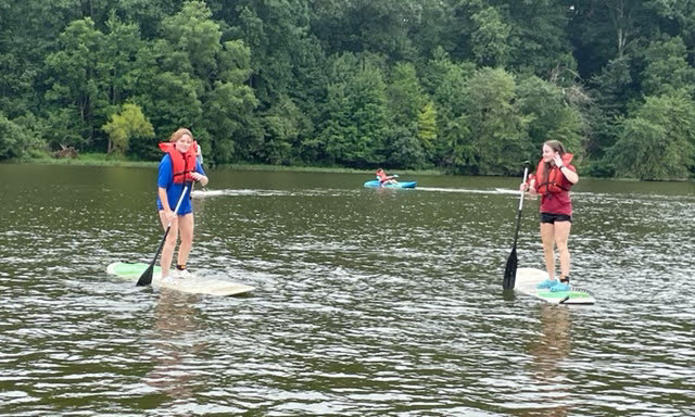 10th grade students paddleboarding on the lake