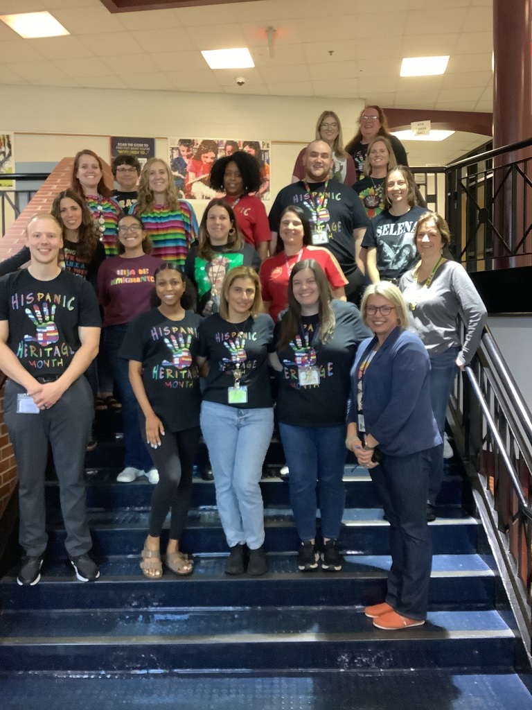 A picture of staff members who wore the hispanic heritage shirt by the stairwell