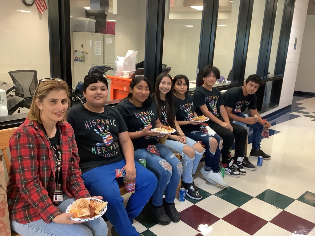 A picture of Mrs. Saadeh and her students enjoying the food. 