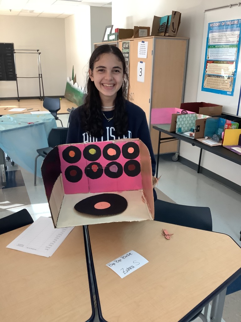 a picture of a student holding up her set. It looks like a record player. 