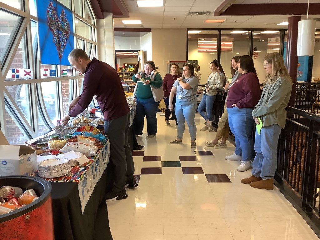A picture of Mr. Stiver carving the Turkey and staff members eagerly waiting