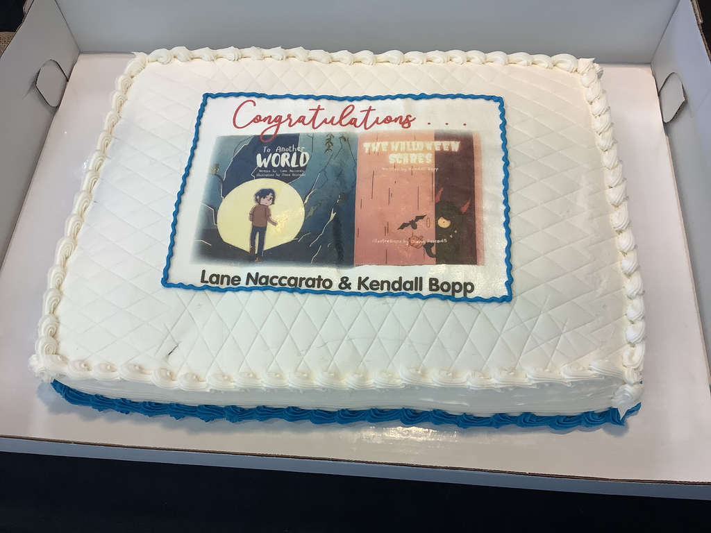A picture of the cake with both books and congratulations on it