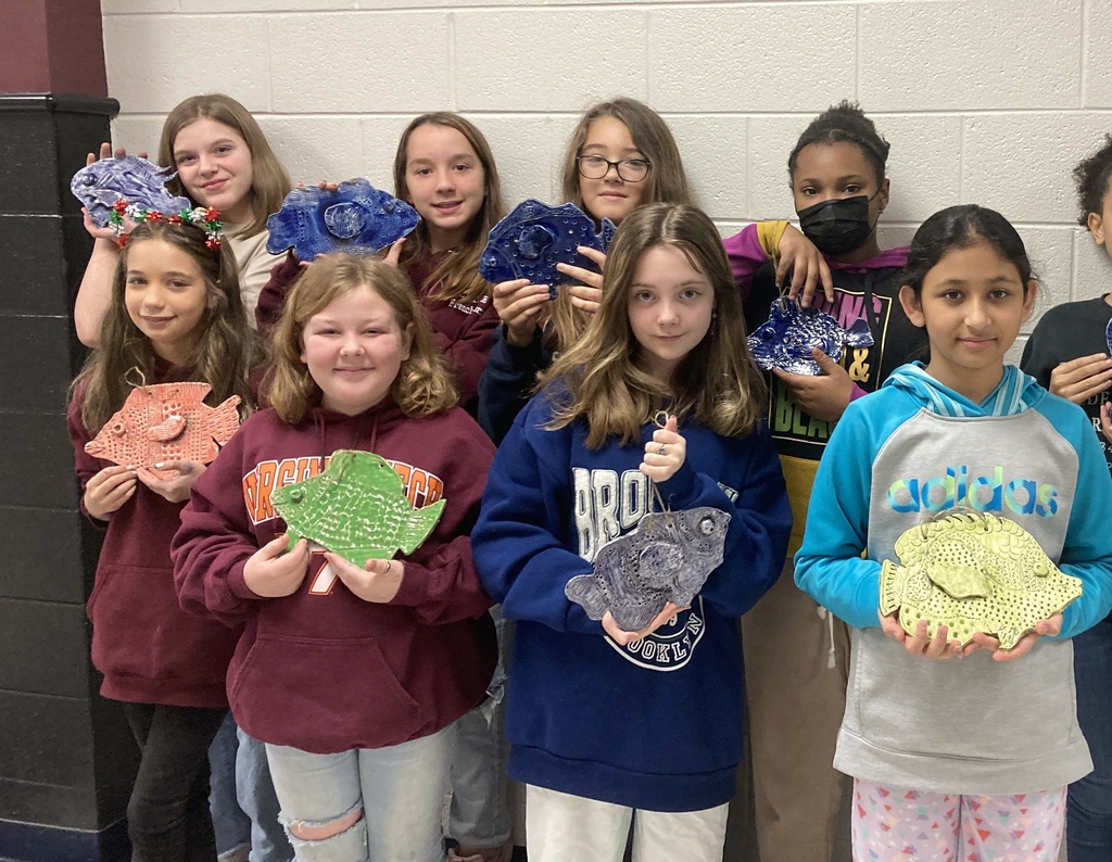 Another picture of a bunch of students holding up their clay fish creations