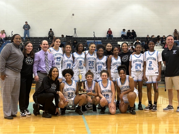 girls and coaches basketball uniforms holding trophy