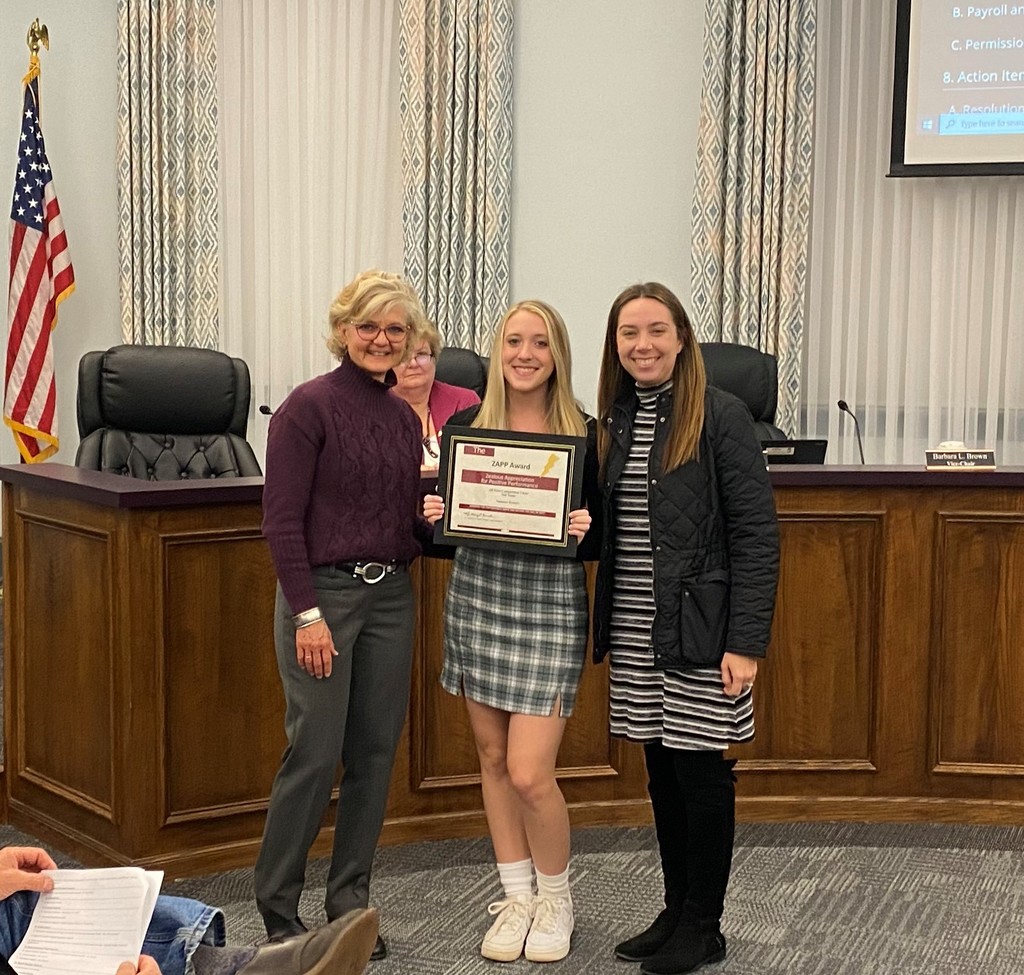 student receives an award from Board Member