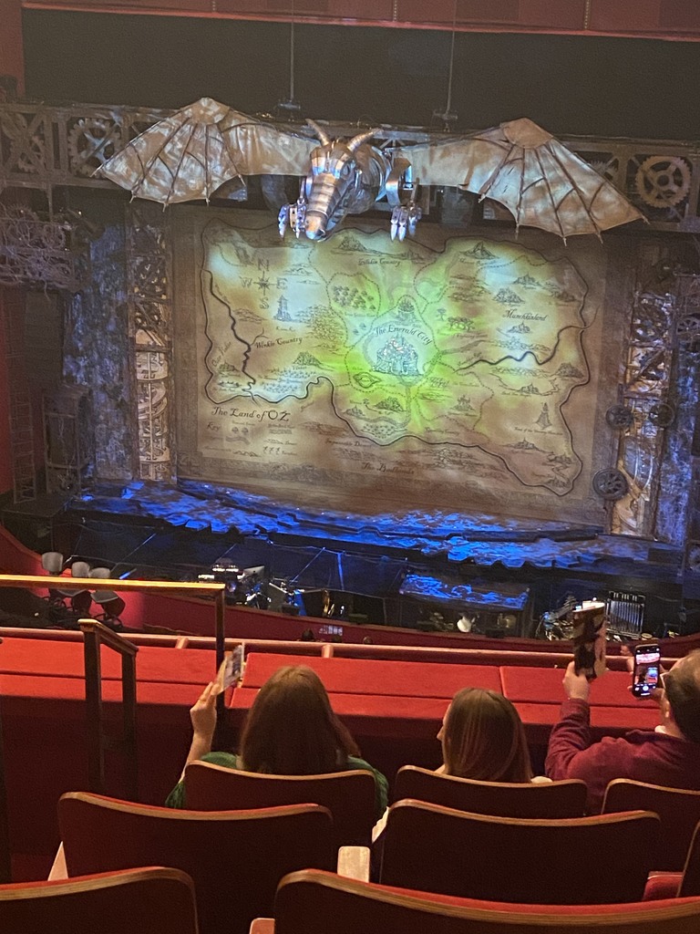 A picture of the decorated stage with a large dragon at the very top of the stage and a map as a backdrop