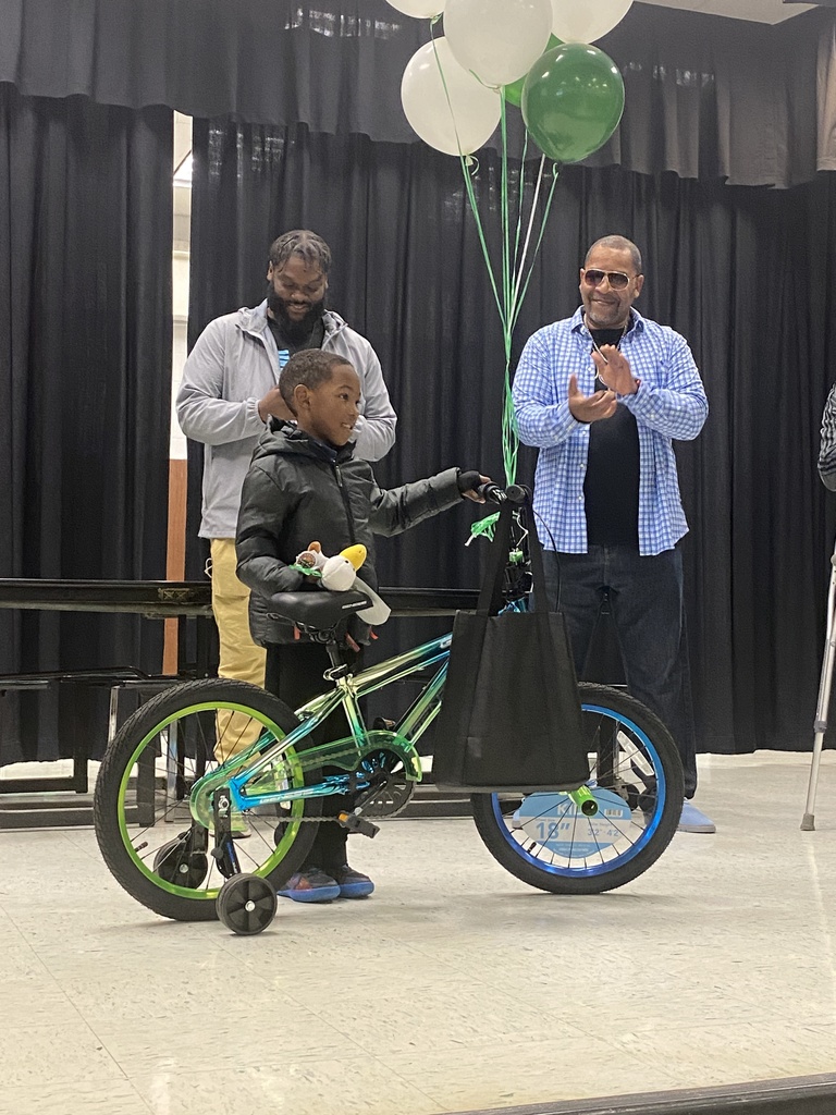 student receives bicycle with balloons