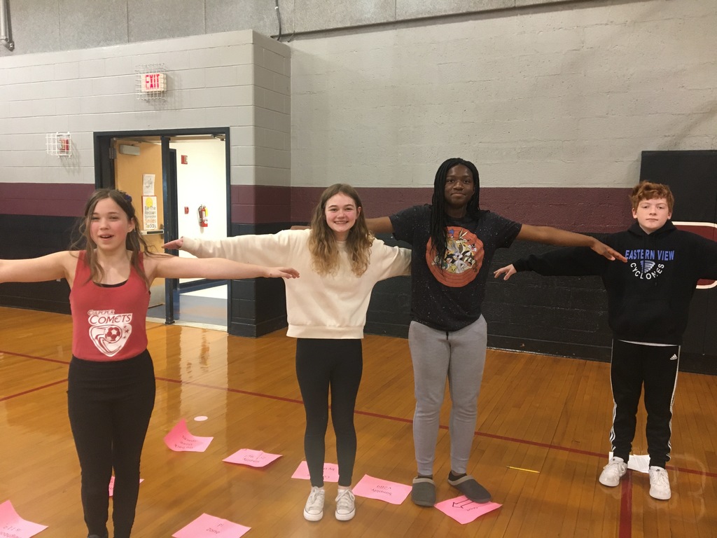 A picture of students making a T with their arms