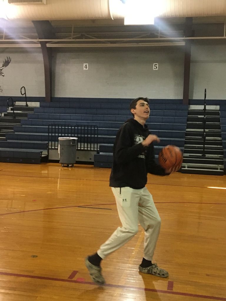 A tall student shooting a basketball
