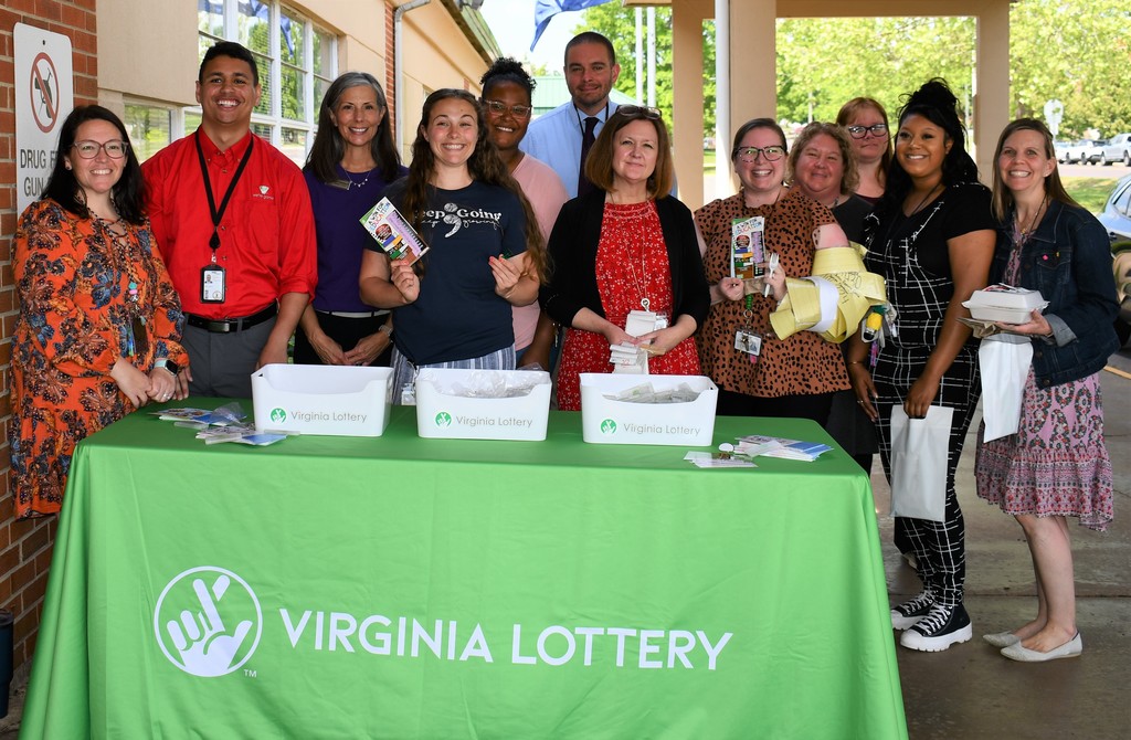 group of teachers behind virginia lottery table