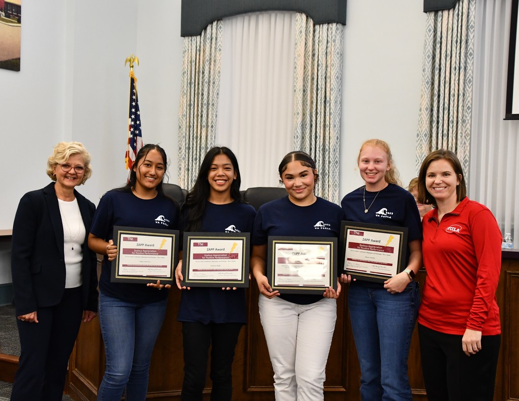 high school students with awards with teacher and board members